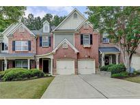Charming brick townhome featuring an attached two-car garage and a well-manicured lawn at 1102 Lexington Dr, Roswell, GA 30075