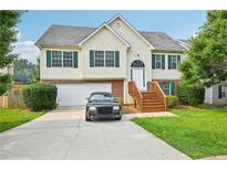 Charming two-story home with green shutters, a well-manicured lawn, and a two-car garage at 1147 Saint Phillips Ct, Locust Grove, GA 30248