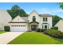 Charming two-story home with manicured lawn, black trim, arched window, and a two-car garage at 3684 Clearbrooke Way, Duluth, GA 30097