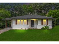 Charming single-story home featuring white siding, a well-manicured lawn, and a covered carport on a tree-lined street at 629 Dunton Se Cir, Smyrna, GA 30082