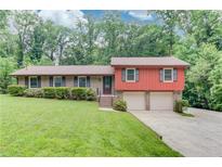 Charming home with a well-manicured lawn and attached two-car garage at 1148 Woodland Cir, Lawrenceville, GA 30043