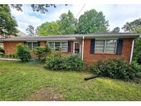 A single story brick home with black shutters and a well-maintained lawn under a cloudy sky at 2480 Sewell Mill Rd, Marietta, GA 30062