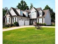 Charming two-story home featuring a well-manicured lawn, two-car garage, and stone accents at 50 Worthington Dr, Villa Rica, GA 30180