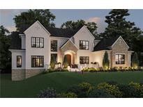 Elegant two-story home featuring a stone and white brick facade, well-manicured lawn, and beautiful landscaping at 120 Wood River Ct, Johns Creek, GA 30097
