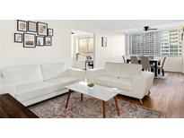 Bright living room features hardwood floors, a modern white sofa set, and an area rug at 215 Piedmont Ne Ave # 1109, Atlanta, GA 30308