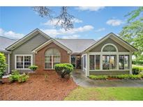 Charming one-story home with brick accents, landscaped yard, and inviting sunroom in a well-manicured neighborhood at 4512 Orchard Trce, Roswell, GA 30076