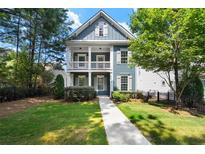Charming two-story home with a welcoming front porch and beautifully landscaped front yard at 1922 Perry Nw Blvd, Atlanta, GA 30318