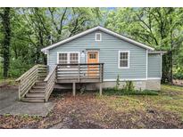 Charming bungalow with light blue siding, wood porch and stairs, and lush greenery at 2803 3Rd Sw Ave, Atlanta, GA 30315