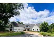 Stunning white farmhouse with a three-car garage and an asphalt driveway at 3842 Ernest W Barrett Sw Pkwy, Marietta, GA 30064