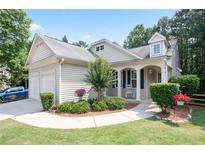 Charming home with a welcoming front porch, lush landscaping, and a two-car attached garage at 428 Redwood Trl, Canton, GA 30114