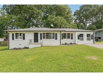 Charming exterior of a freshly painted brick home with black shutters and a well-manicured lawn at 1261 Cliffwood Se Dr, Smyrna, GA 30080