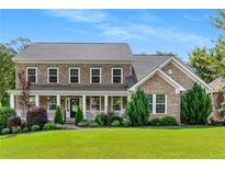 Beautiful brick home with a welcoming front porch and manicured landscaping at 129 Millstone Way, Canton, GA 30115