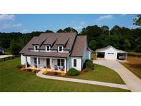 Beautiful, modern farmhouse-style home with a well-manicured lawn and separate garage at 3508 Cox Cemetery Rd, Social Circle, GA 30025