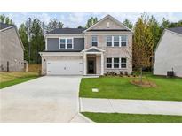 Beautiful two-story home featuring brick and gray siding, a well-manicured lawn, and a two-car garage at 6104 Marigold Way, Atlanta, GA 30349