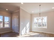 Bright dining room with a modern chandelier and large windows, showcasing the light wood flooring and neutral wall paint at 1996 Deco Dr, Kennesaw, GA 30144