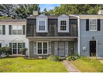 Charming townhome featuring a well-maintained lawn and a classic front entrance with shuttered windows at 5575 Wells Circle, Stone Mountain, GA 30087