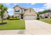 Charming two-story home with stone accents, well-manicured lawn, and a two-car garage at 1998 Lakeview Bend Way, Buford, GA 30519