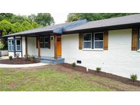 Charming brick home with updated windows, shutters, and a bright front door at 2786 Knollview Dr, Decatur, GA 30034