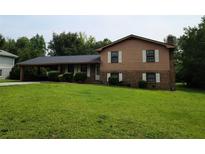 Charming two-story home featuring a brick facade and inviting front yard with mature landscaping at 2104 Moon Sw Dr, Conyers, GA 30094
