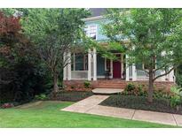 Charming two-story home featuring mature landscaping, a welcoming front porch, and a brick pathway at 453 Carter Se Ave, Atlanta, GA 30317