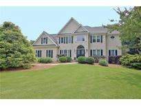 Stately two-story home featuring a lush green lawn and manicured landscaping at 104 Hidden Springs Ln, Peachtree City, GA 30269