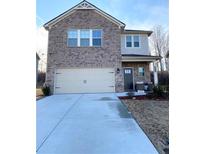 Two-story brick home featuring a two-car garage and well-maintained front yard at 2757 Malton Way, Loganville, GA 30052
