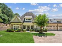 Charming home featuring stone accents, a lush lawn, and a three car garage at 2855 Middlecreek Way # 2855, Cumming, GA 30041