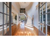Grand foyer with curved staircase, hardwood floors, and abundant natural light at 652 Pathview Ct, Dacula, GA 30019
