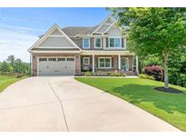 Charming two-story home with a well-manicured lawn and a long driveway leading to an attached two-car garage at 466 Sweet Apple Ln, Buford, GA 30518