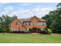 Charming two-story brick home with a well-manicured lawn and mature landscaping at 125 Ancient Oak Ln, Stockbridge, GA 30281