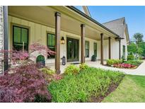 Charming front porch with craftsman columns and lush landscaping at 131 Forsyth Park Ln, Woodstock, GA 30188