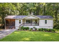 Charming single-story home features a screened porch and well-manicured lawn and landscape at 1744 Blossom Ln, Austell, GA 30168