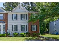 Two-story townhouse featuring a mix of brick and vinyl siding with black shutters and well-maintained front lawn at 5920 Hampton Ct, College Park, GA 30349