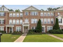 Brick townhome featuring well-manicured landscaping, symmetrical design, and a welcoming facade at 3328 Chastain Gardens Nw Dr, Kennesaw, GA 30144