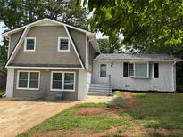 Two-story home featuring a two-tone exterior, front yard, and multi-pane windows at 1094 Amber Sw Rdg, Lilburn, GA 30047