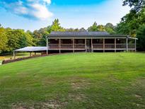 Charming ranch-style home featuring a full, spacious porch with wooden railings and a large grassy front yard at 360 Parr Farm Rd, Covington, GA 30016