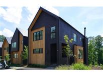 Modern home exterior featuring dark siding, natural wood accents, and a sleek, contemporary design at 1168 Mado Loop, Chattahoochee Hills, GA 30268