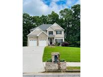 Charming two-story home features a stone facade, well-manicured lawn, and a two-car garage at 7052 Camp Falls Ct, Winston, GA 30187
