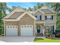 Charming two-story home with stone accents, a two-car garage, and a beautifully landscaped front yard at 7052 Camp Falls Ct, Winston, GA 30187