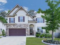 Charming two-story home with stone accents, a two-car garage, and a well-manicured front yard at 423 Livingston Pt, Acworth, GA 30102