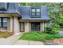 Charming townhouse with brick facade, mature landscaping, and a distinctive slate roof at 57 Cantey Nw Pl, Atlanta, GA 30327