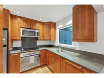 Well-lit kitchen featuring wood cabinets, stainless steel appliances and gray countertops at 57 Cantey Nw Pl, Atlanta, GA 30327