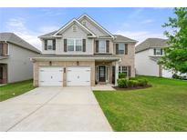 Charming two-story home with a brick facade, two-car garage, and a well-manicured front lawn at 2680 Lower Village Dr, Ellenwood, GA 30294