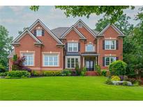 Beautiful two-story brick home with lush lawn, landscaping, and symmetrical design at 2688 Hidden Falls Ne Dr, Buford, GA 30519