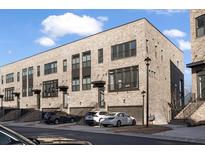 Modern townhome exterior featuring a brick facade, private garages, and manicured landscaping at 3208 Sonnet Se Walk, Atlanta, GA 30339