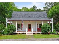 Charming home with a welcoming front porch, American flag, and lovely landscaping at 121 Gosdin Rd, Palmetto, GA 30268