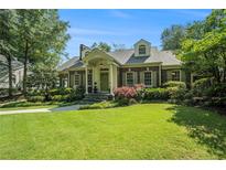 Charming brick home boasts a manicured lawn, mature trees, and inviting front entrance at 1821 N Rock Springs Ne Rd, Atlanta, GA 30324