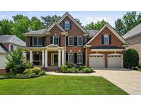 Beautiful two-story brick home with a well-manicured lawn, two-car garage and inviting front porch at 828 Ivy Ne Cv, Norcross, GA 30071