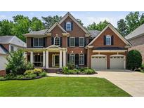 Stately brick home with well-manicured lawn, two car garage, and inviting covered front porch at 828 Ivy Ne Cv, Norcross, GA 30071