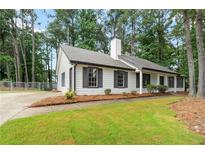 Charming single-story home featuring black shutters, white siding, and a well-manicured front lawn at 40 Melton Way, Covington, GA 30016